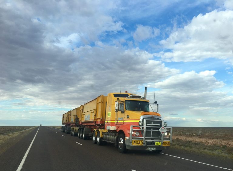 a logistics truck driving on a highway on slightly overcast day