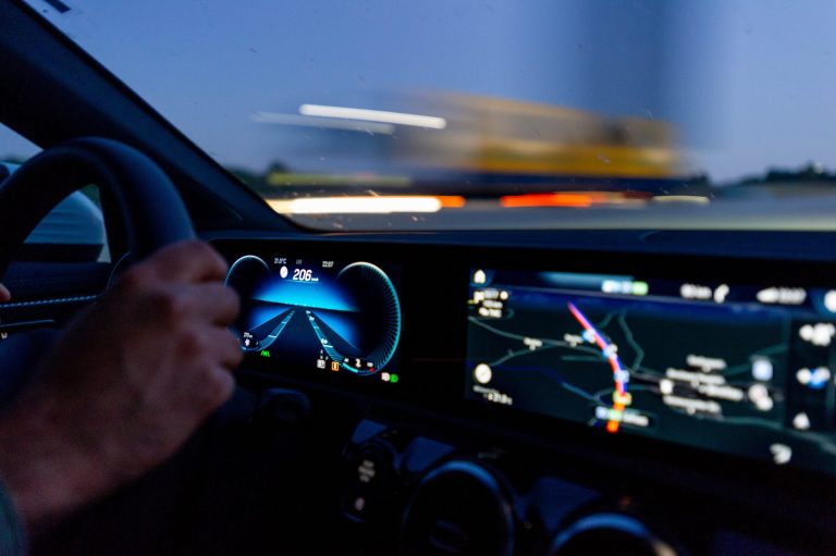 a modern digital vehicle dashboard showing speedometer and gps directions