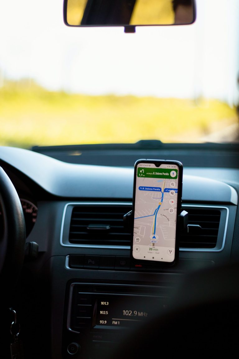 a smartphone with gps directions on a dashboard holster inside a vehicle