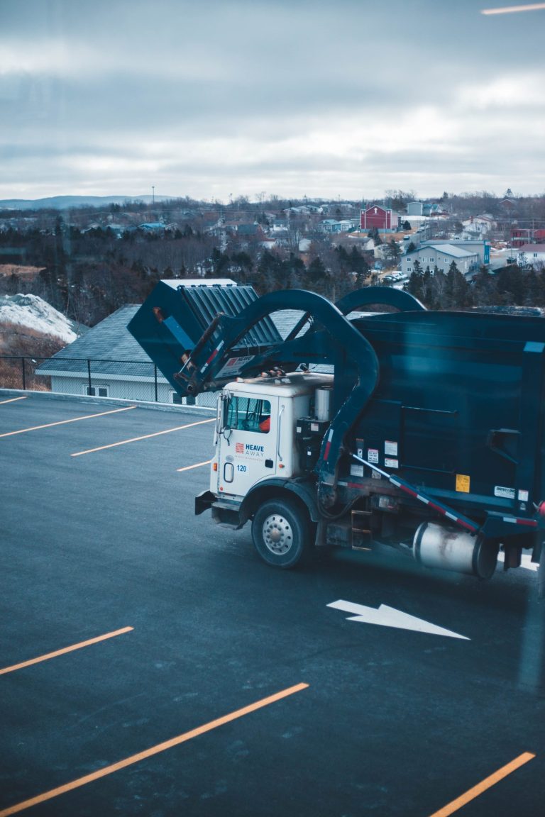 waste management disposal truck with pto sensor engaged getting ready to drop bin off